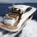A woman relaxes on a Prestige 42S yacht that floats through the water against the backdrop of a populated peninsula